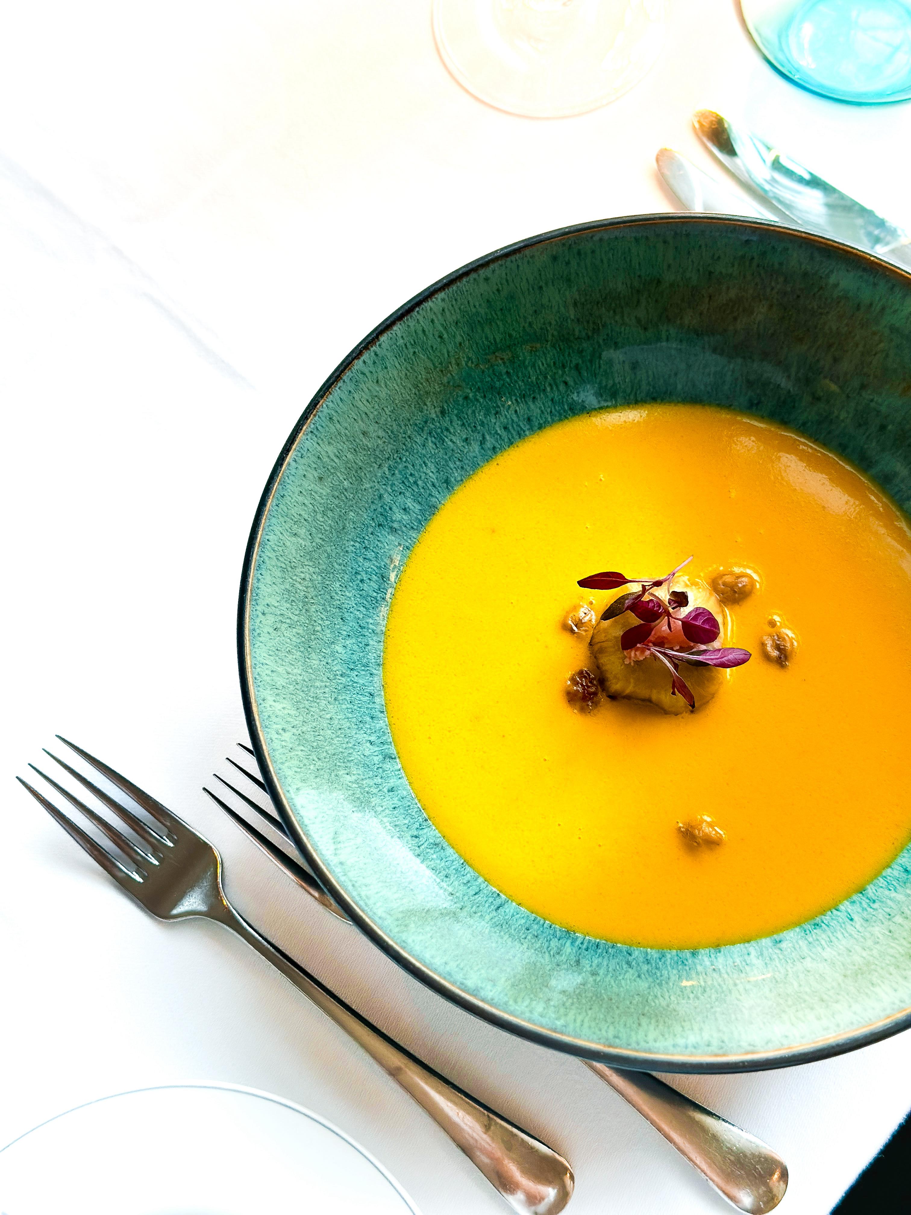 Goldgelbe Kürbissuppe in einem Türkisen Keramik Suppenteller